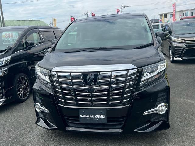 Front and side view of a 2016 Toyota Alphard luxury minivan, showcasing its bold grille, sleek headlights, and spacious, premium design